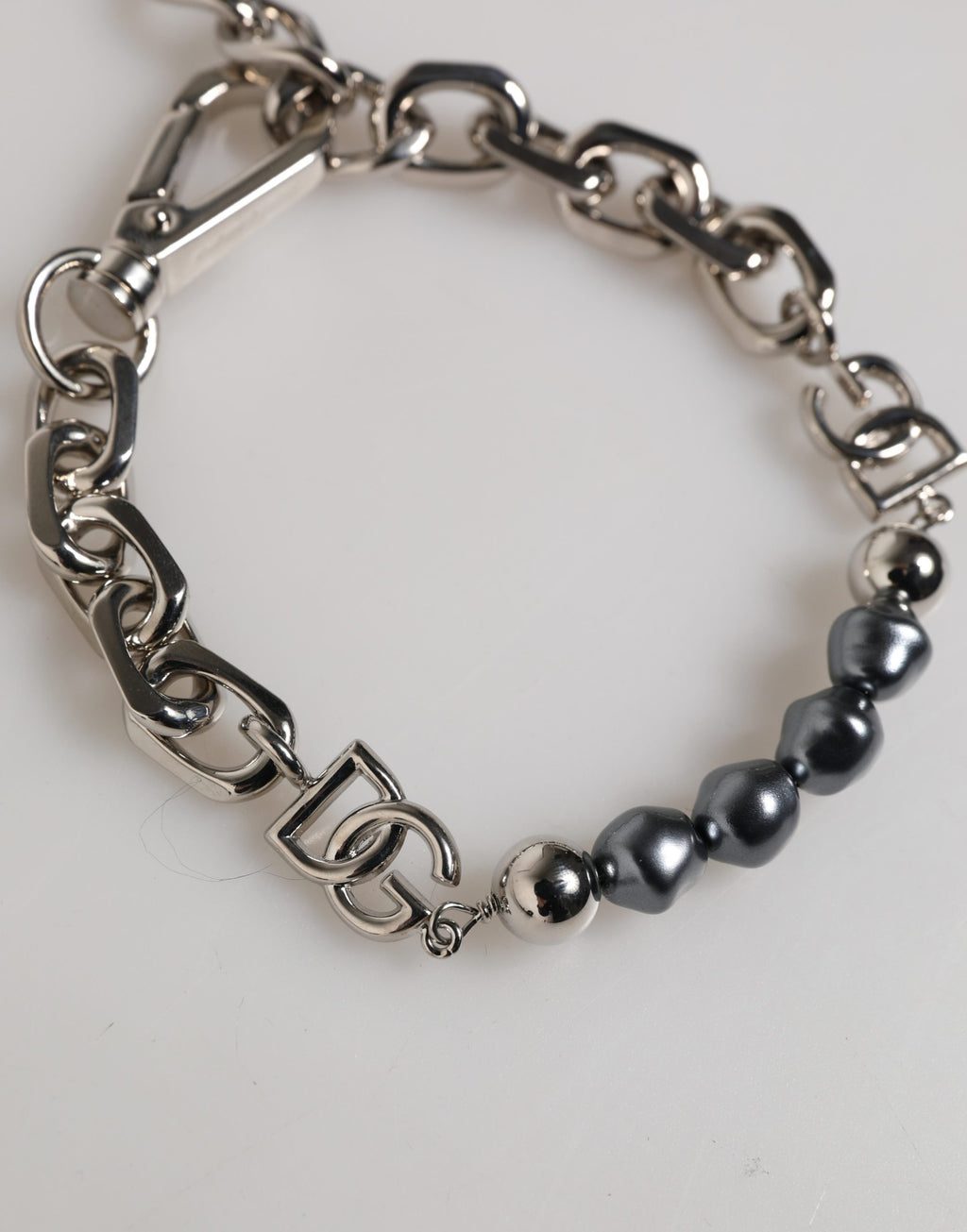 Bracciale Dolce & Gabbana con catena color argento, chiusura a moschettone, logo e perle grigie