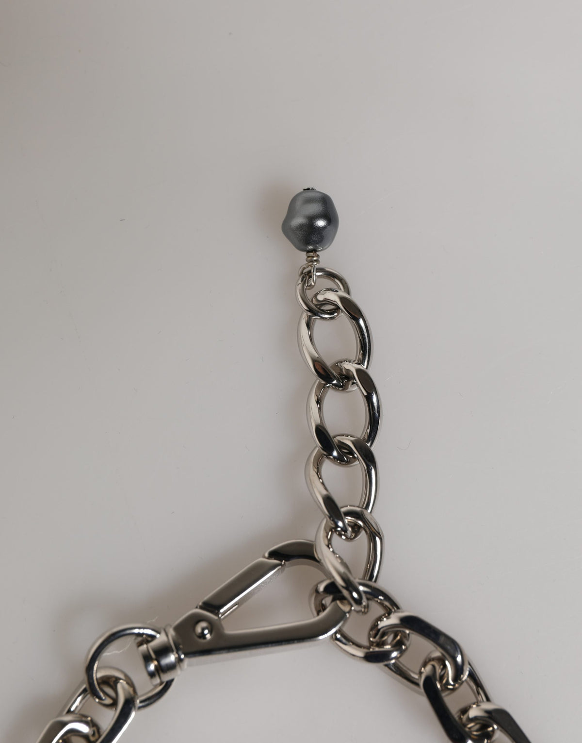 Bracciale Dolce & Gabbana con catena color argento, chiusura a moschettone, logo e perle grigie