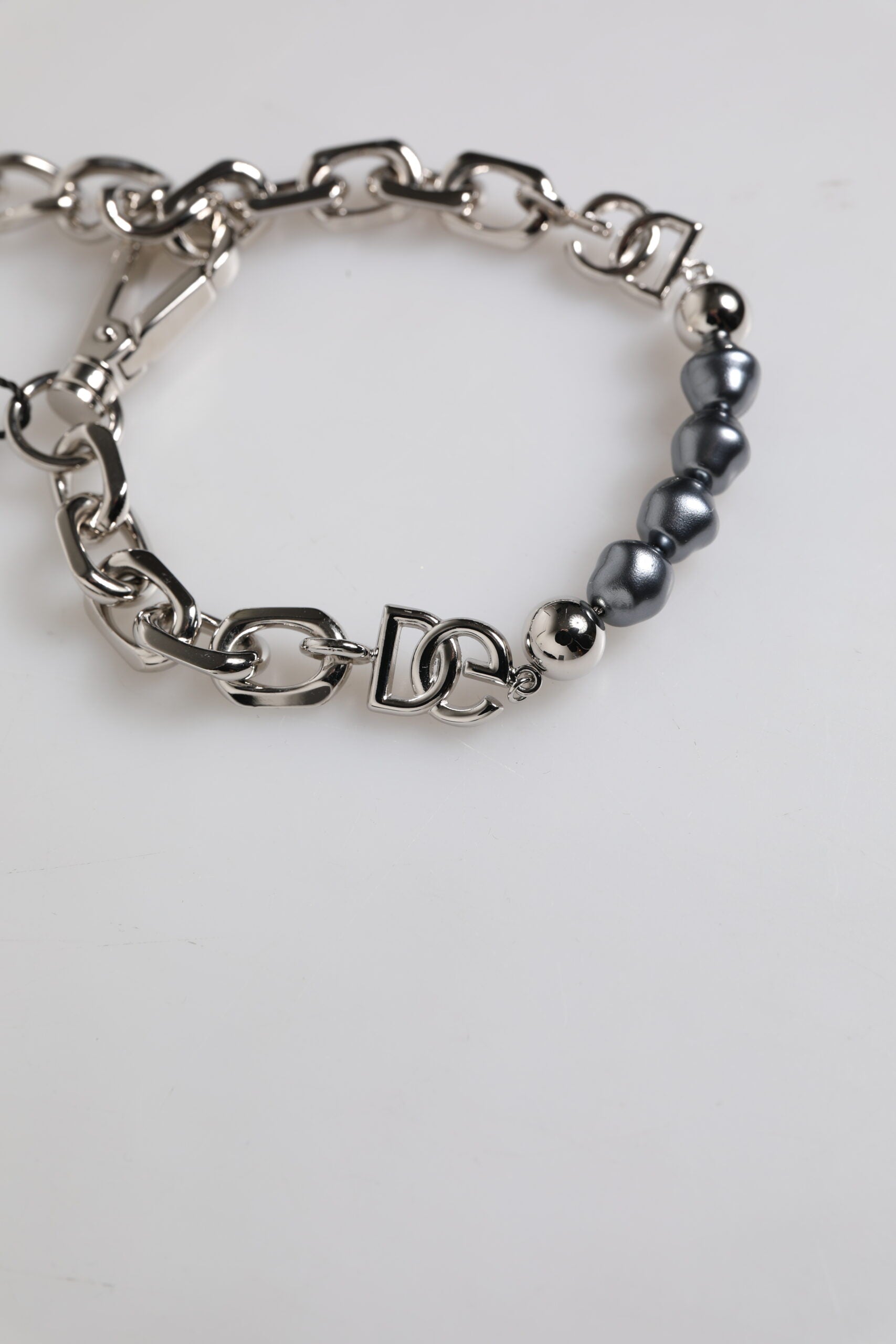 Bracciale Dolce & Gabbana con catena color argento, chiusura a moschettone, logo e perle grigie