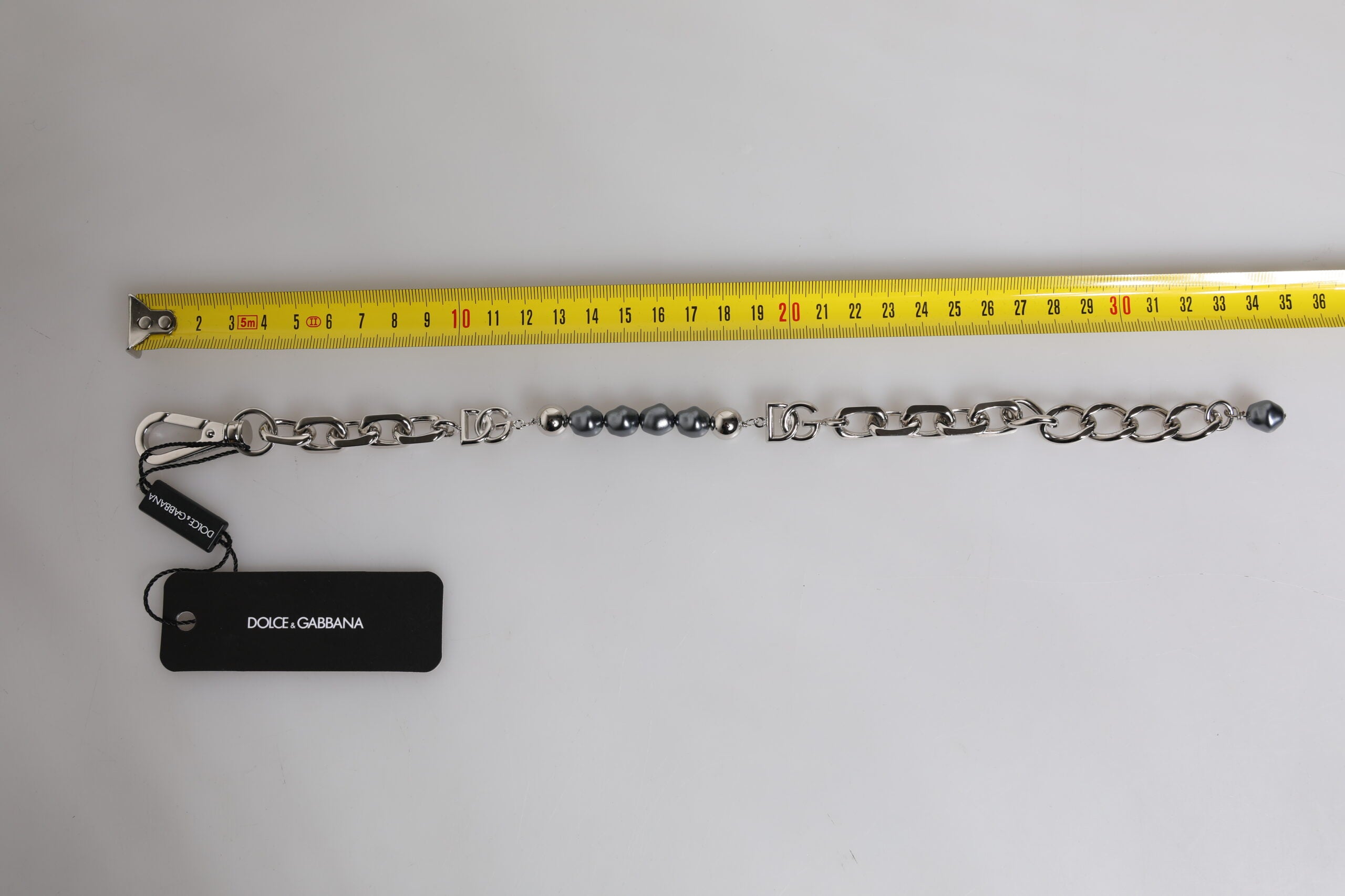 Bracciale Dolce & Gabbana con catena color argento, chiusura a moschettone, logo e perle grigie