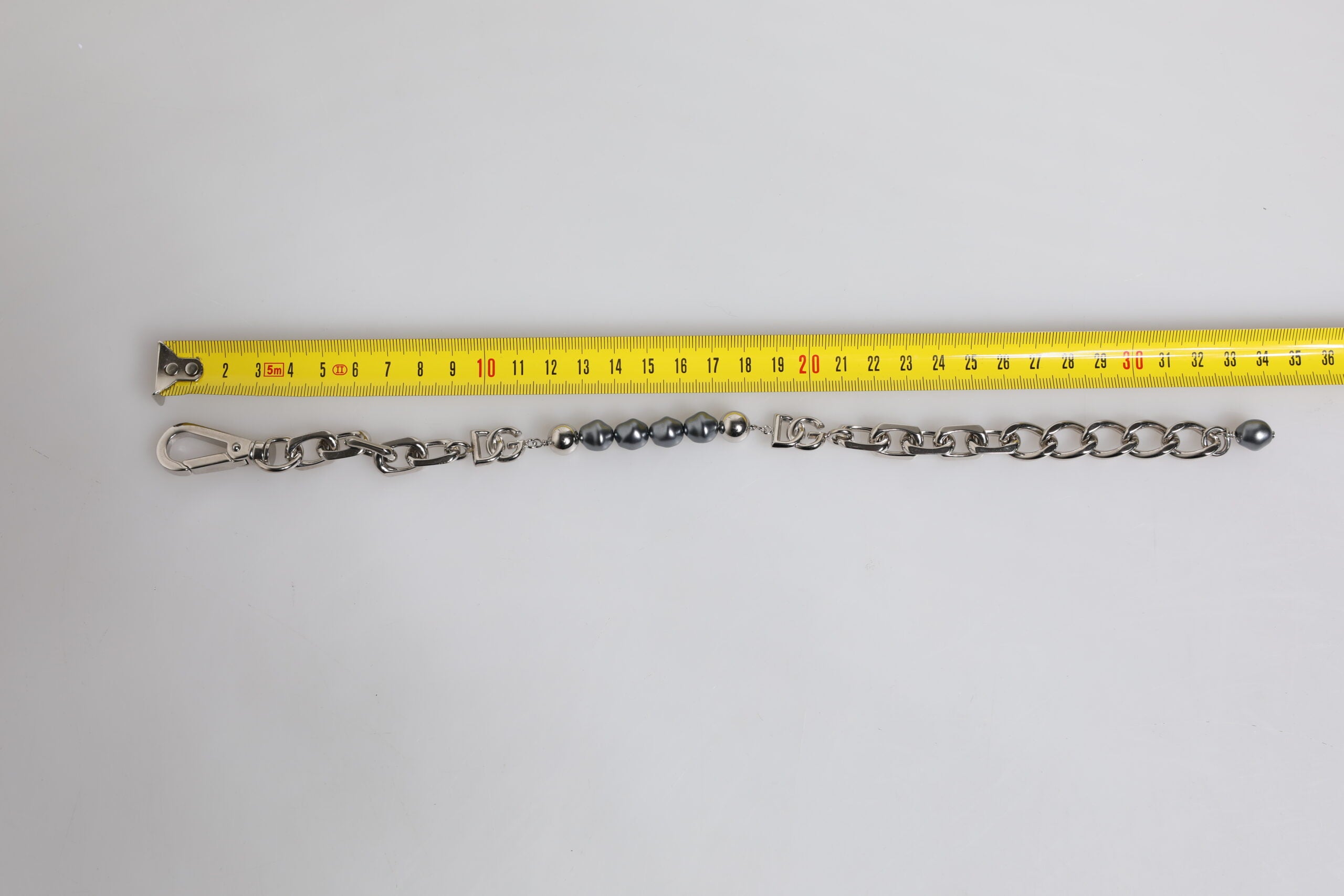 Bracciale Dolce & Gabbana con catena color argento, chiusura a moschettone, logo e perle grigie