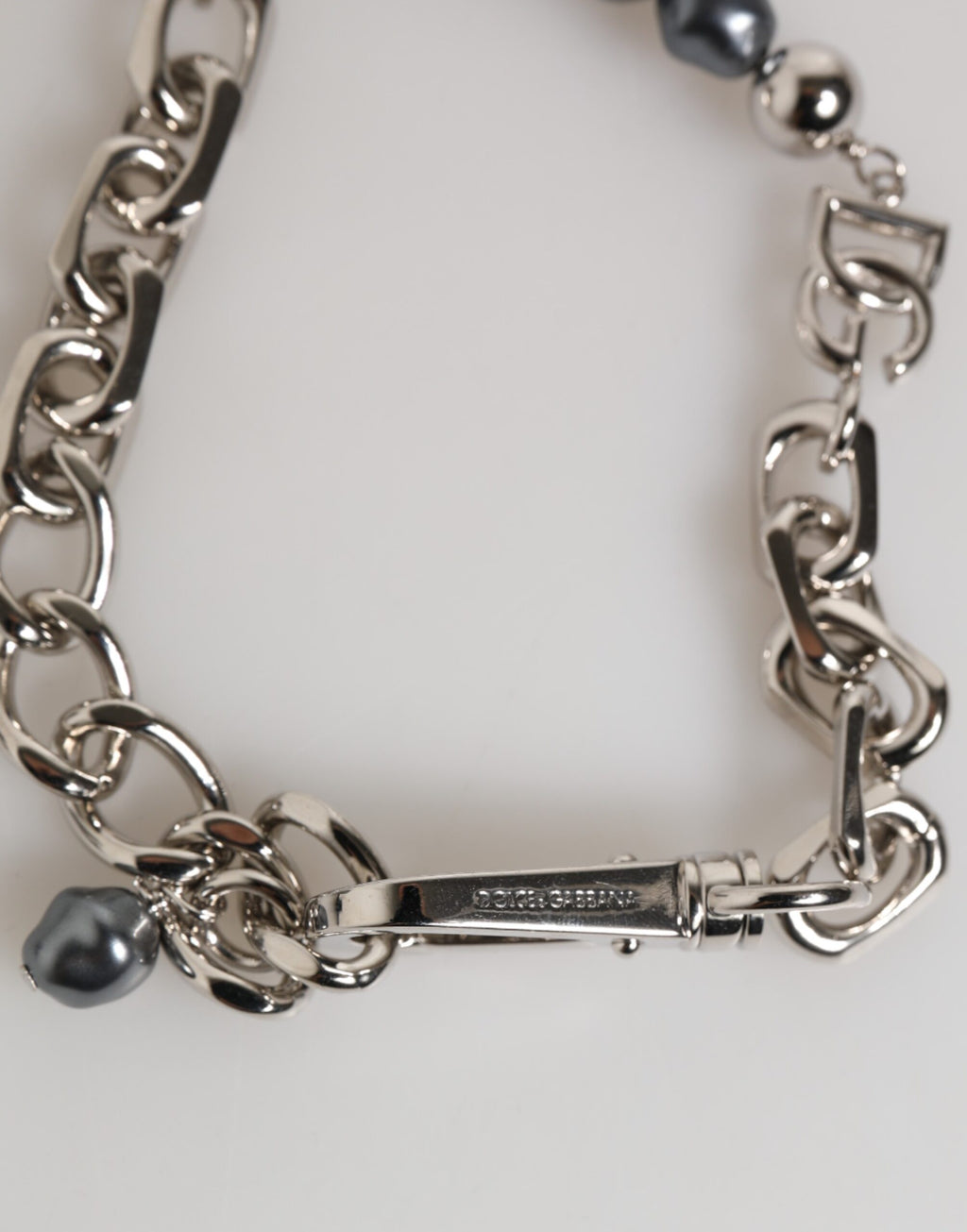 Bracciale Dolce & Gabbana con catena color argento, chiusura a moschettone, logo e perle grigie