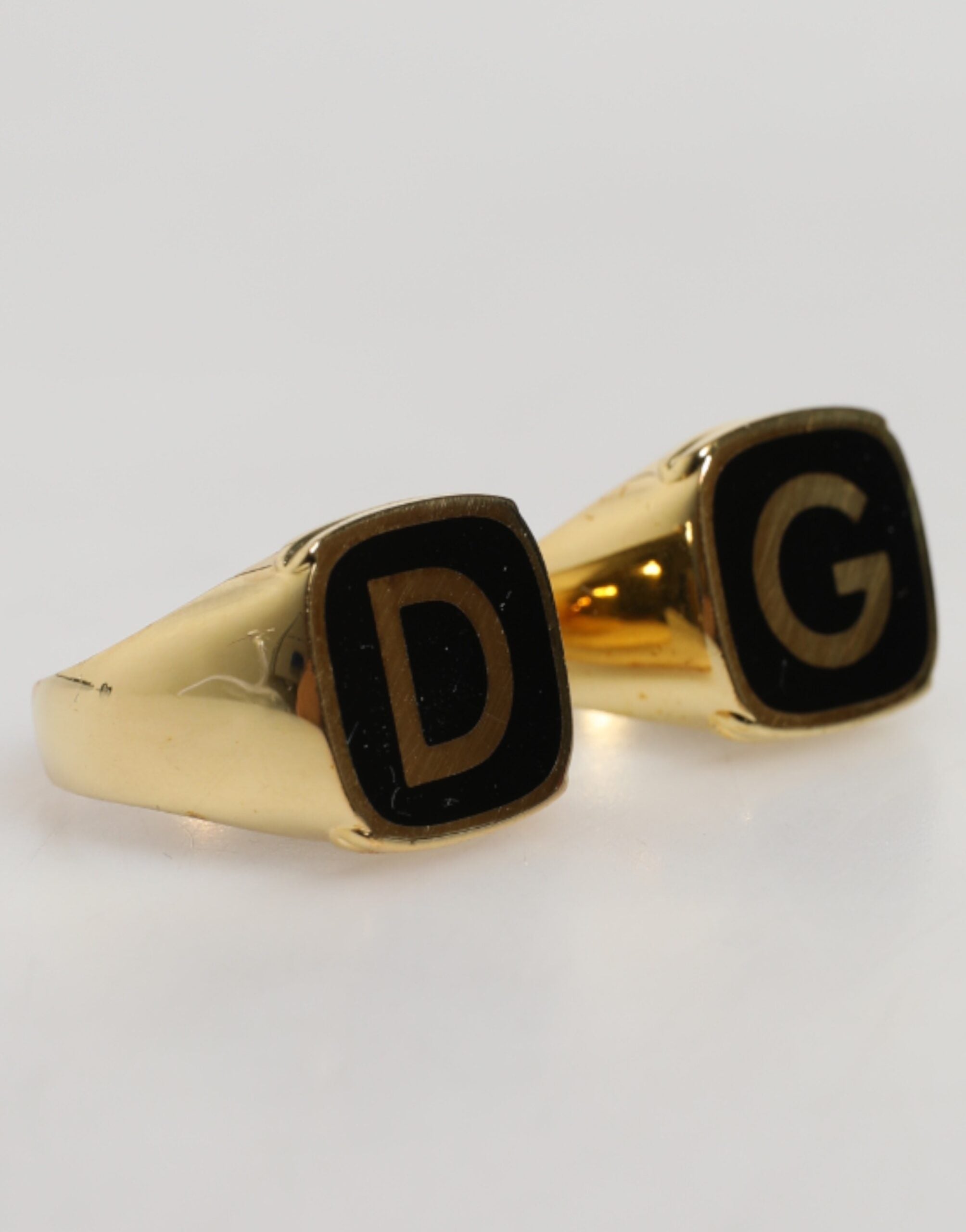 Anelli regolabili Dolce & Gabbana color oro in ottone nero smaltato con logo "DG"